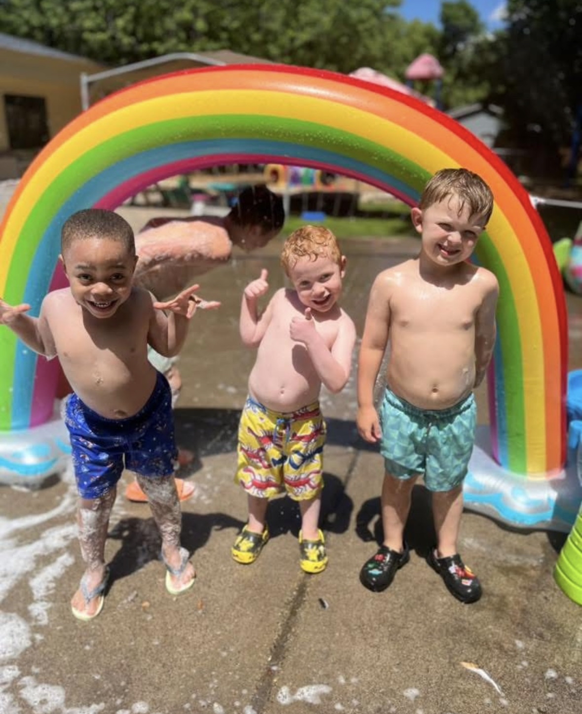 boys playing in rainbow sprinkler 3 young boys playing in rainbow sprinkler