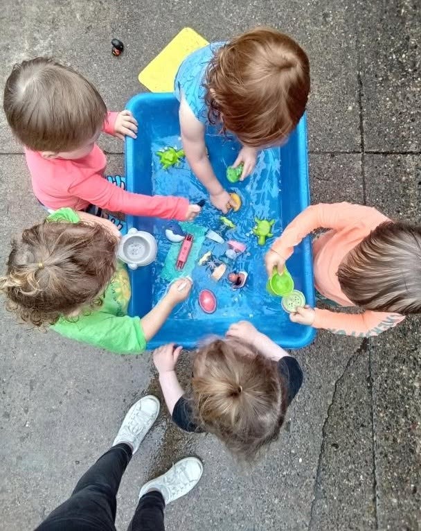 Toddlers playing together at the water table