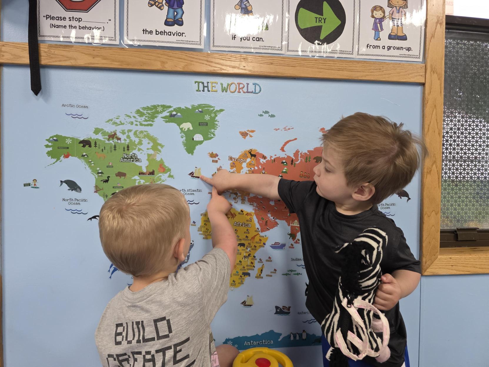 Preschoolers exploring a world map at Creative Kids Academy Apple Valley