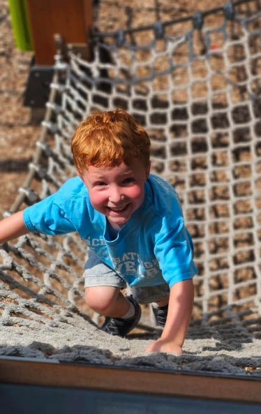 School-age child on the climbing wall at Creative Kids Academy