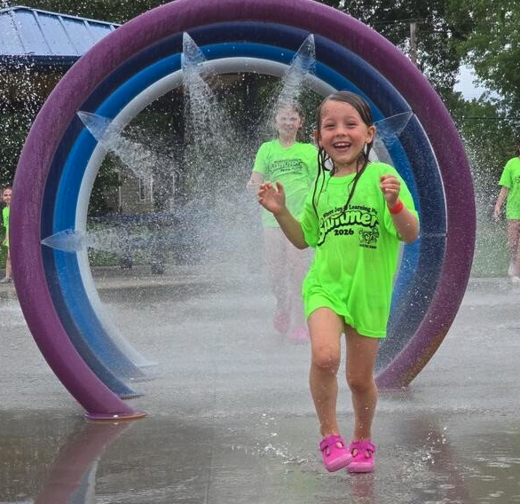 Children playing at the splash pad on a summer field trip