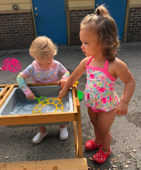 Toddlers playing together at the water table