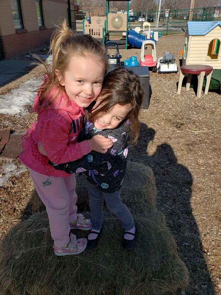 Two friends sharing a hug during outdoor play