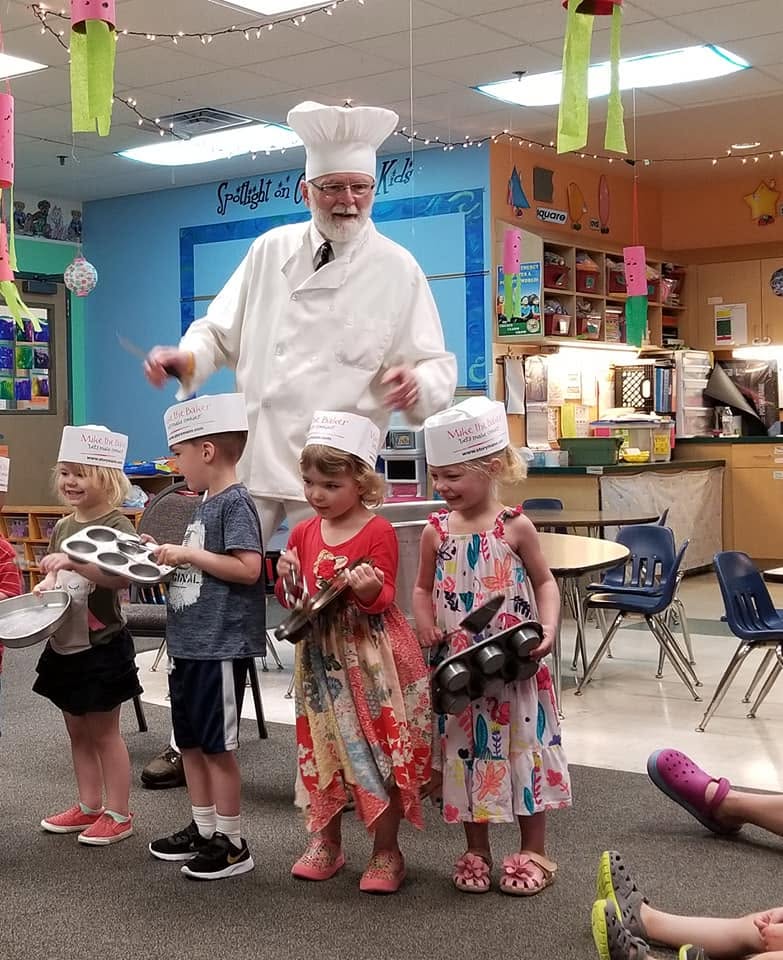 Children enjoying a visit from Mike the Baker during a special event