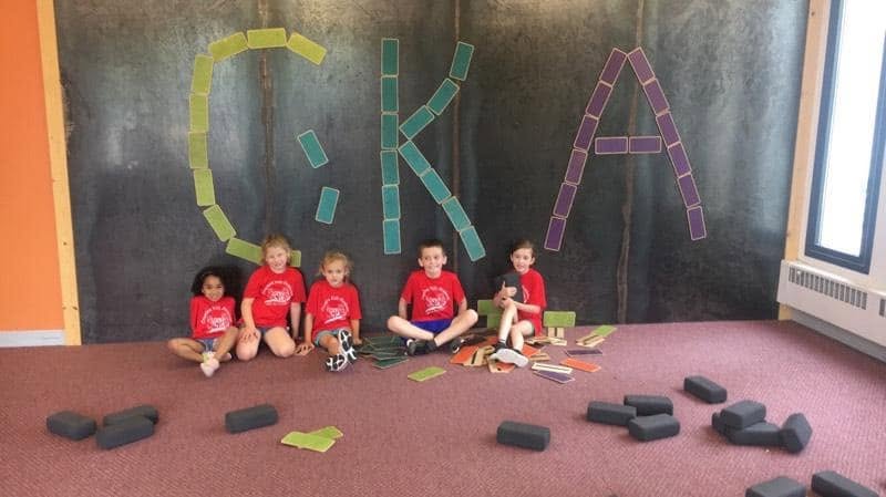 School-age children building the CKA logo out of blocks