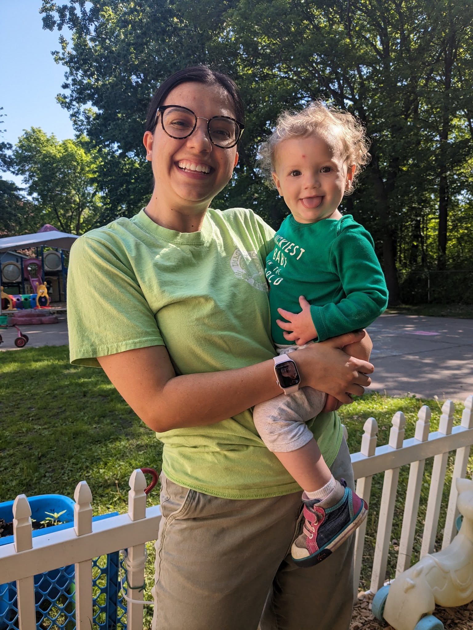 A teacher outdoors holding a baby