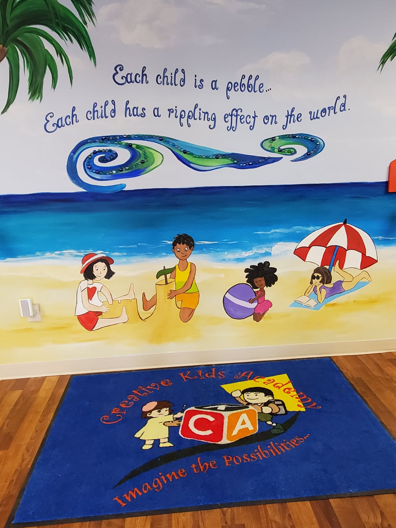 Mural with the quote Each child is a pebble, each child has a rippling effect on the world in the entryway at Creative Kids Academy Maplewood