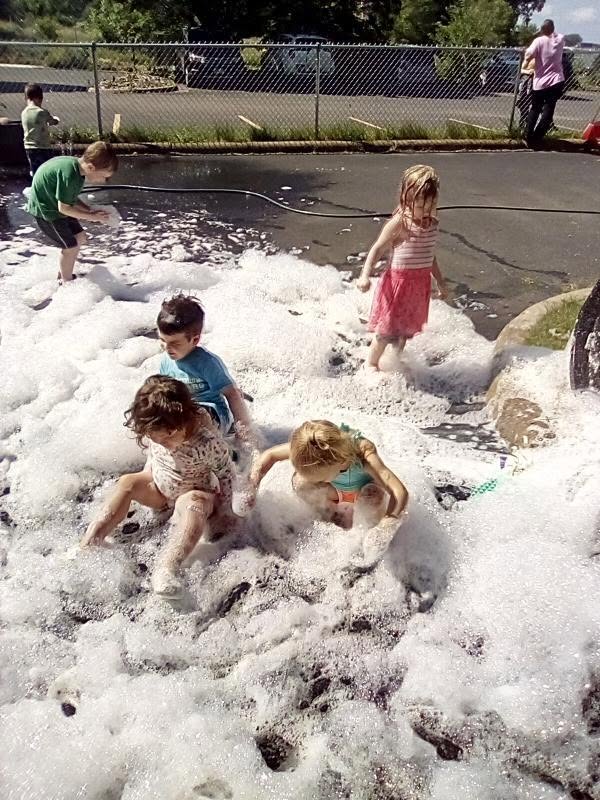 Children playing in bubble foam outside at Creative Kids Academy Maplewood
