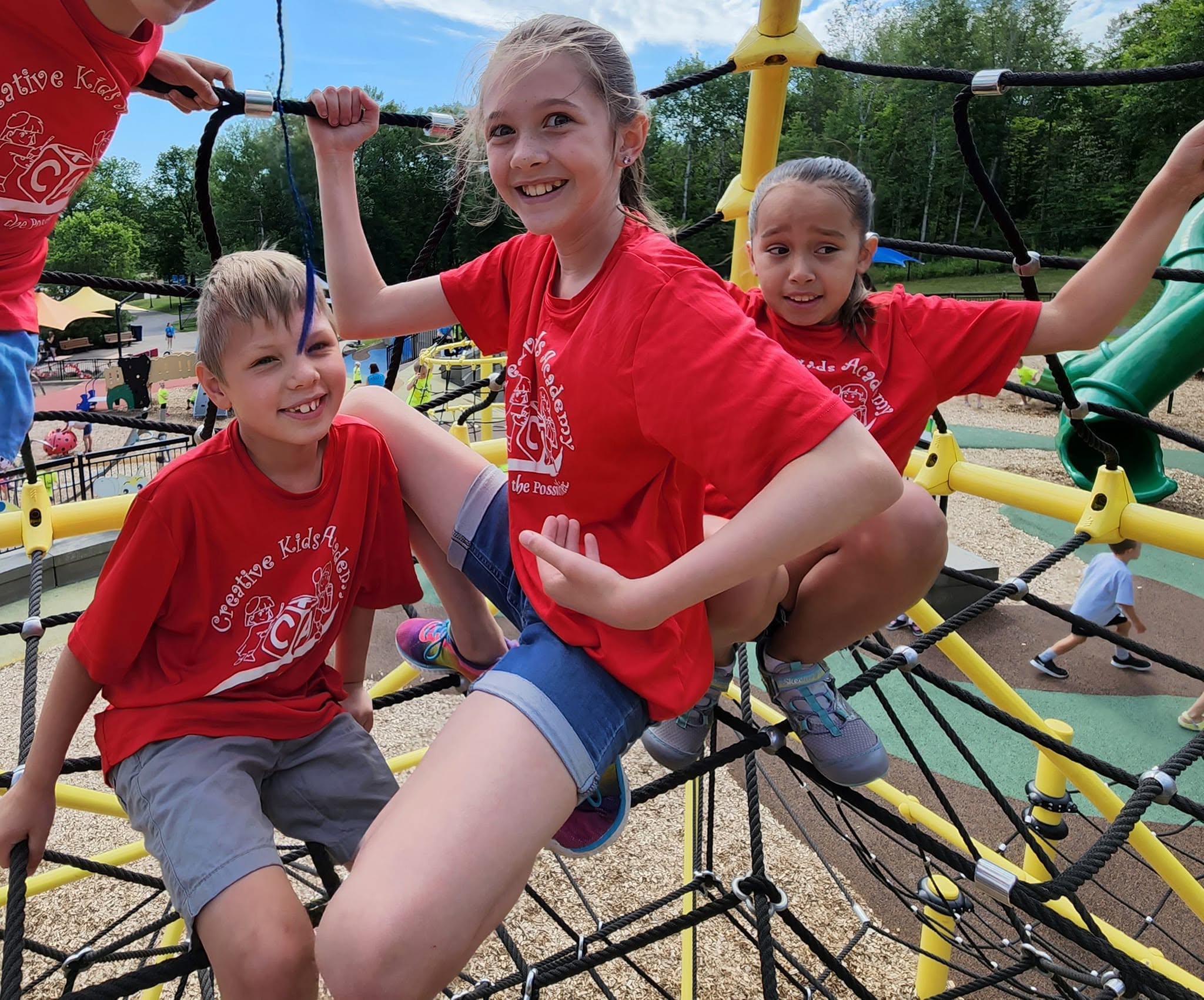 School-age campers climbing together on the playground