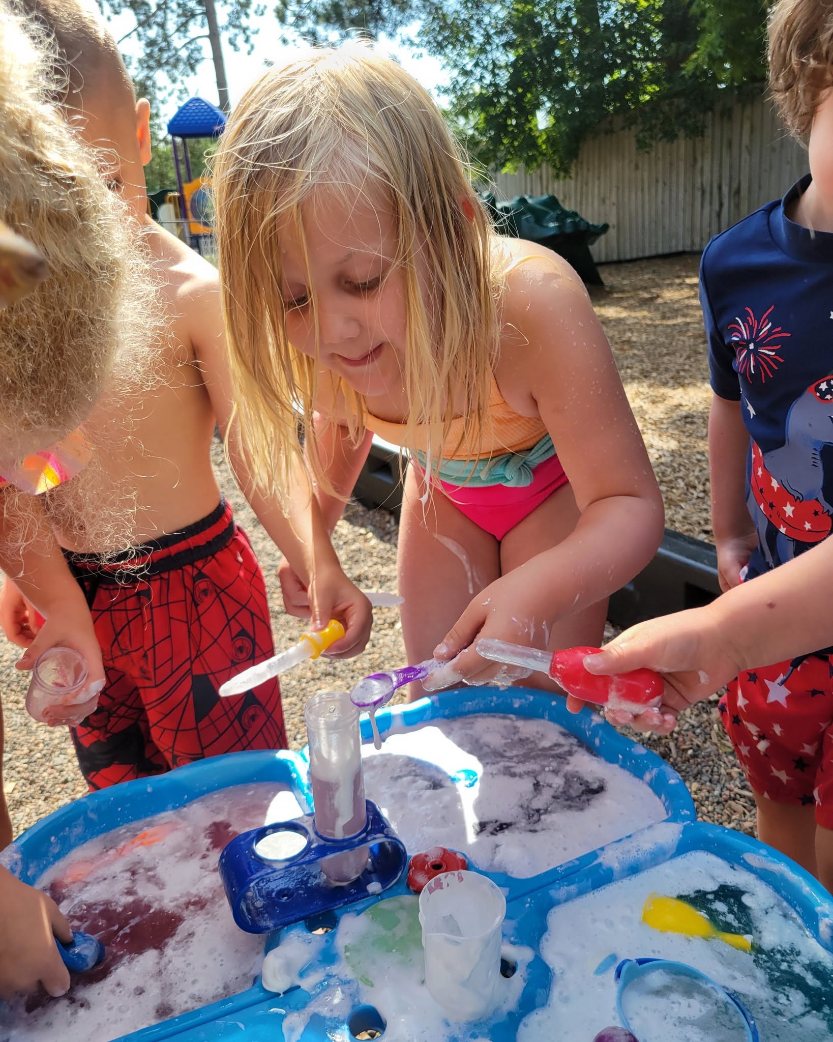 Children exploring a hands-on science activity at the water table at Creative Kids Academy Zimmerman