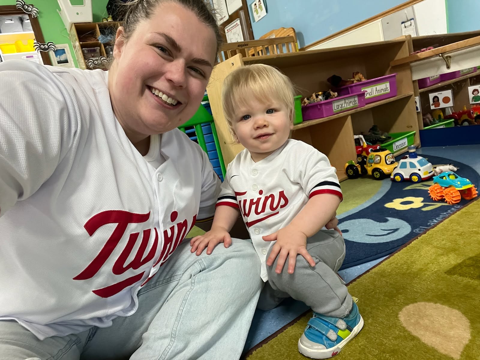 A teacher holding a smiling toddler