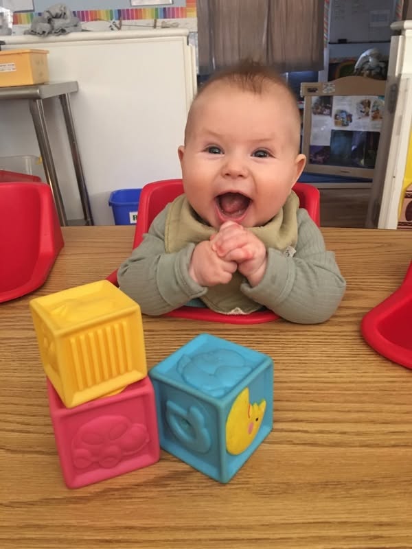 A happy infant playing with blocks at Creative Kids Academy Minnetonka
