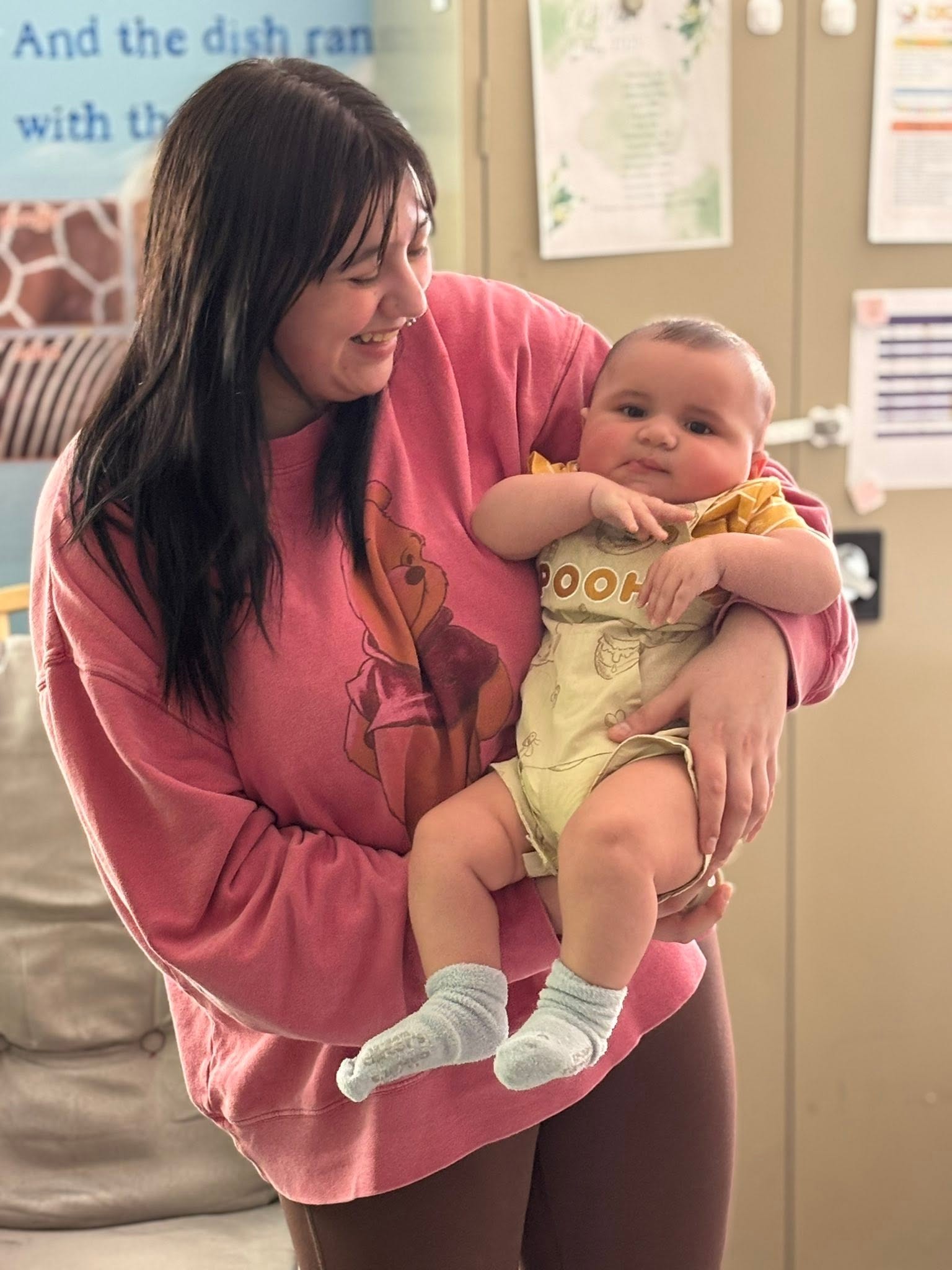 Teacher holding a happy baby in the infant room