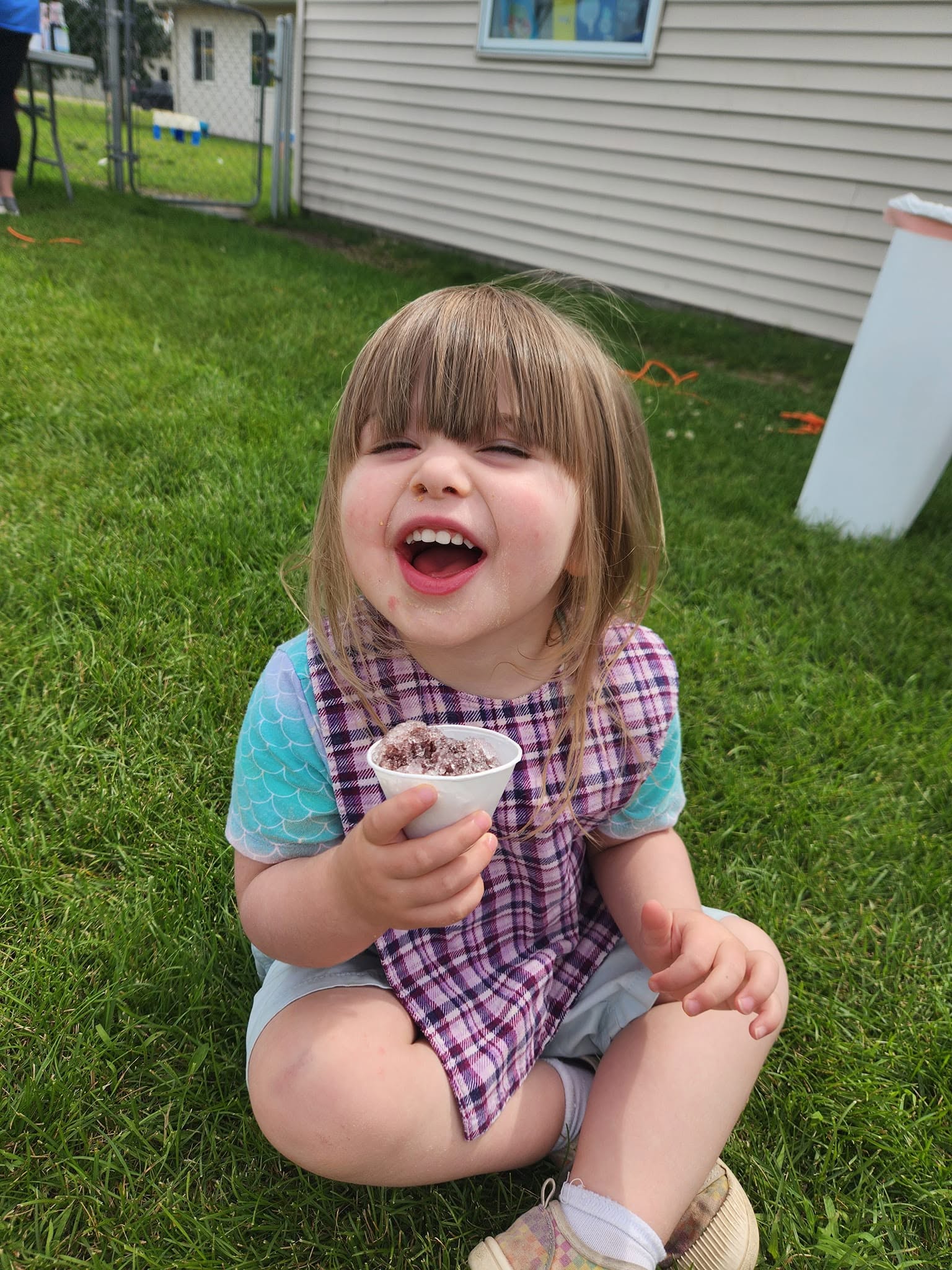 A toddler enjoying a shaved ice treat outdoors at Creative Kids Academy Elk River