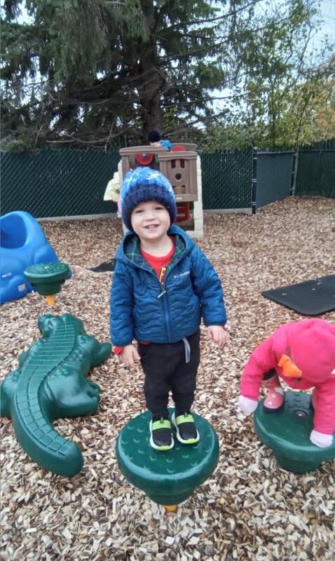 A toddler playing on the outdoor playground at Creative Kids Academy Minnetonka
