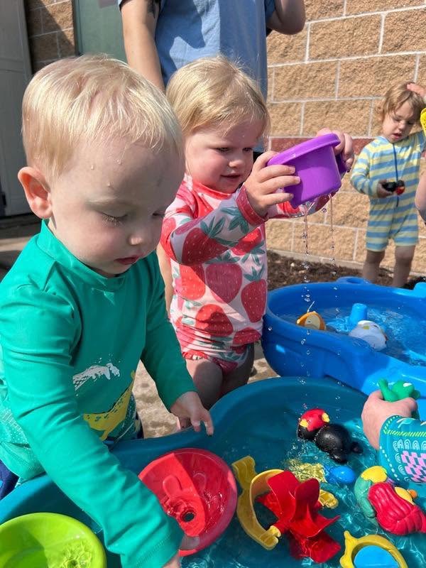 Toddlers playing at the outdoor water table at Creative Kids Academy Centerville