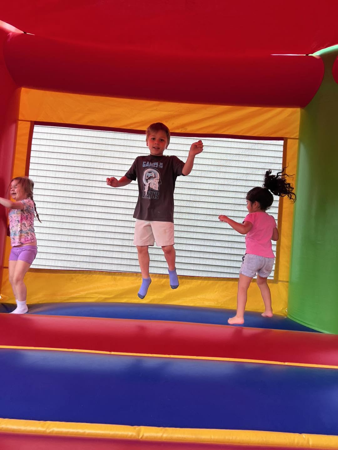 Children jumping and playing in a bounce house at Creative Kids Academy Zimmerman