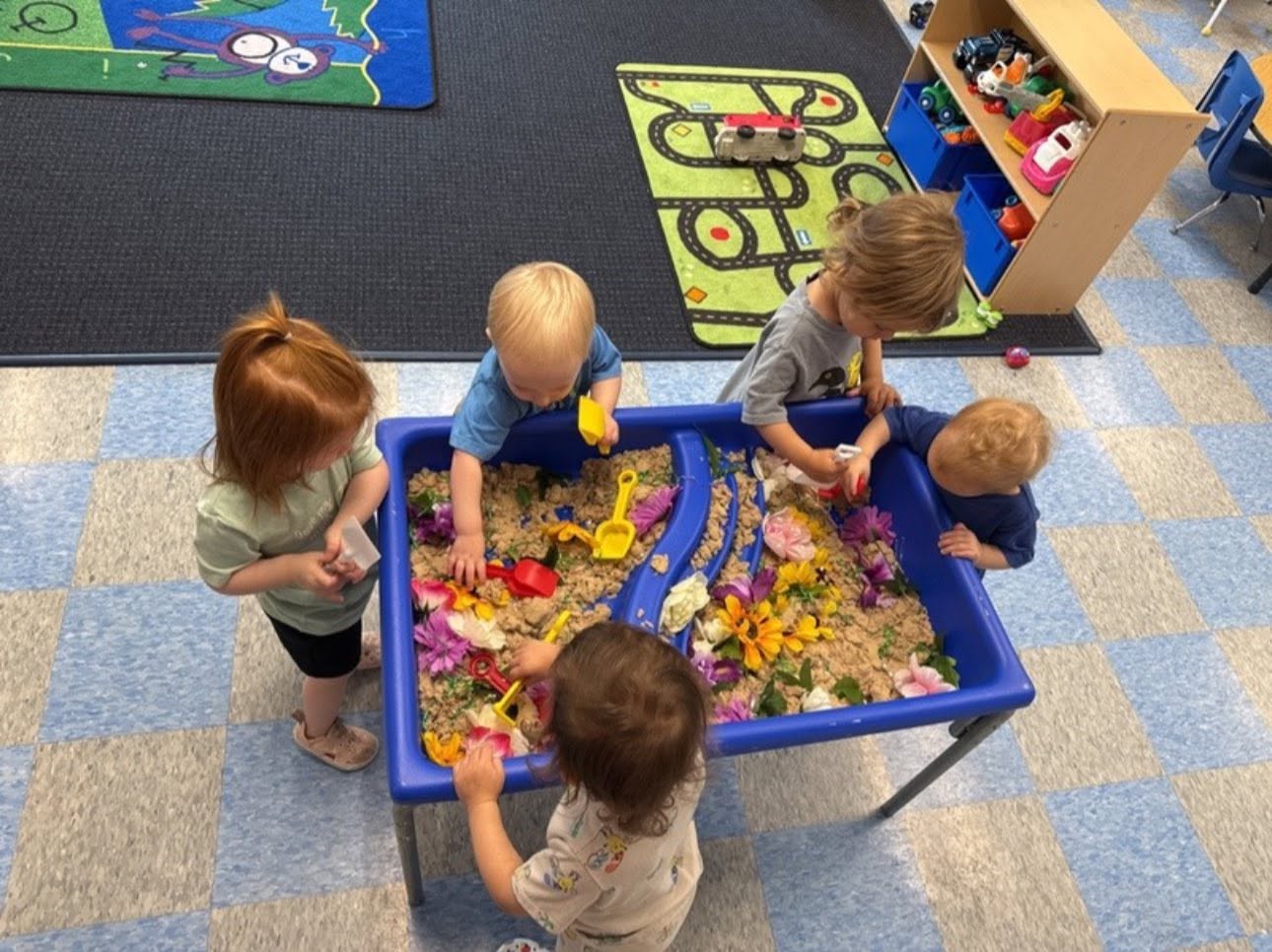 Toddlers exploring a flower sensory table at Creative Kids Academy Centerville