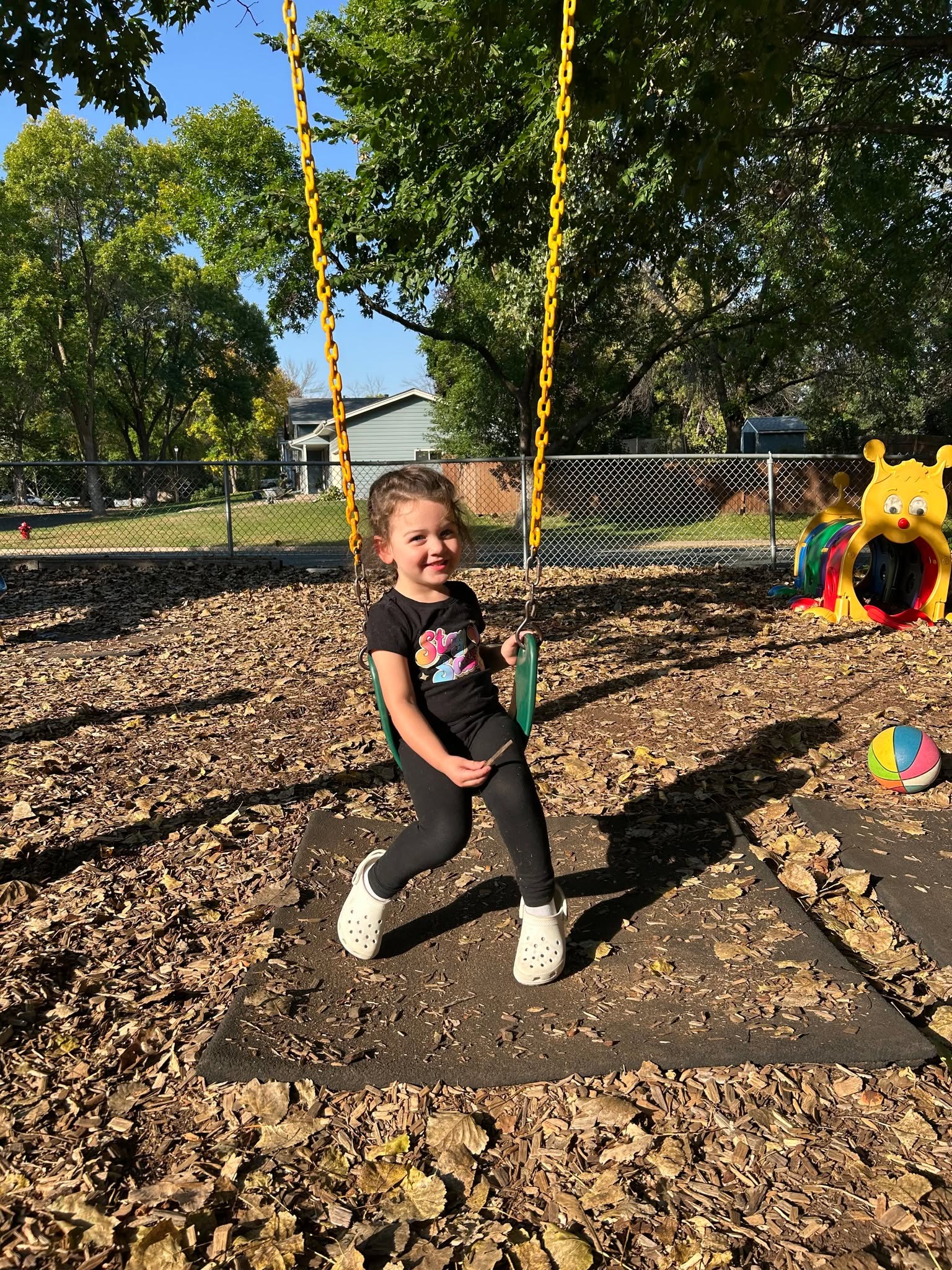 A preschooler playing on the swings at Creative Kids Academy Maple Grove