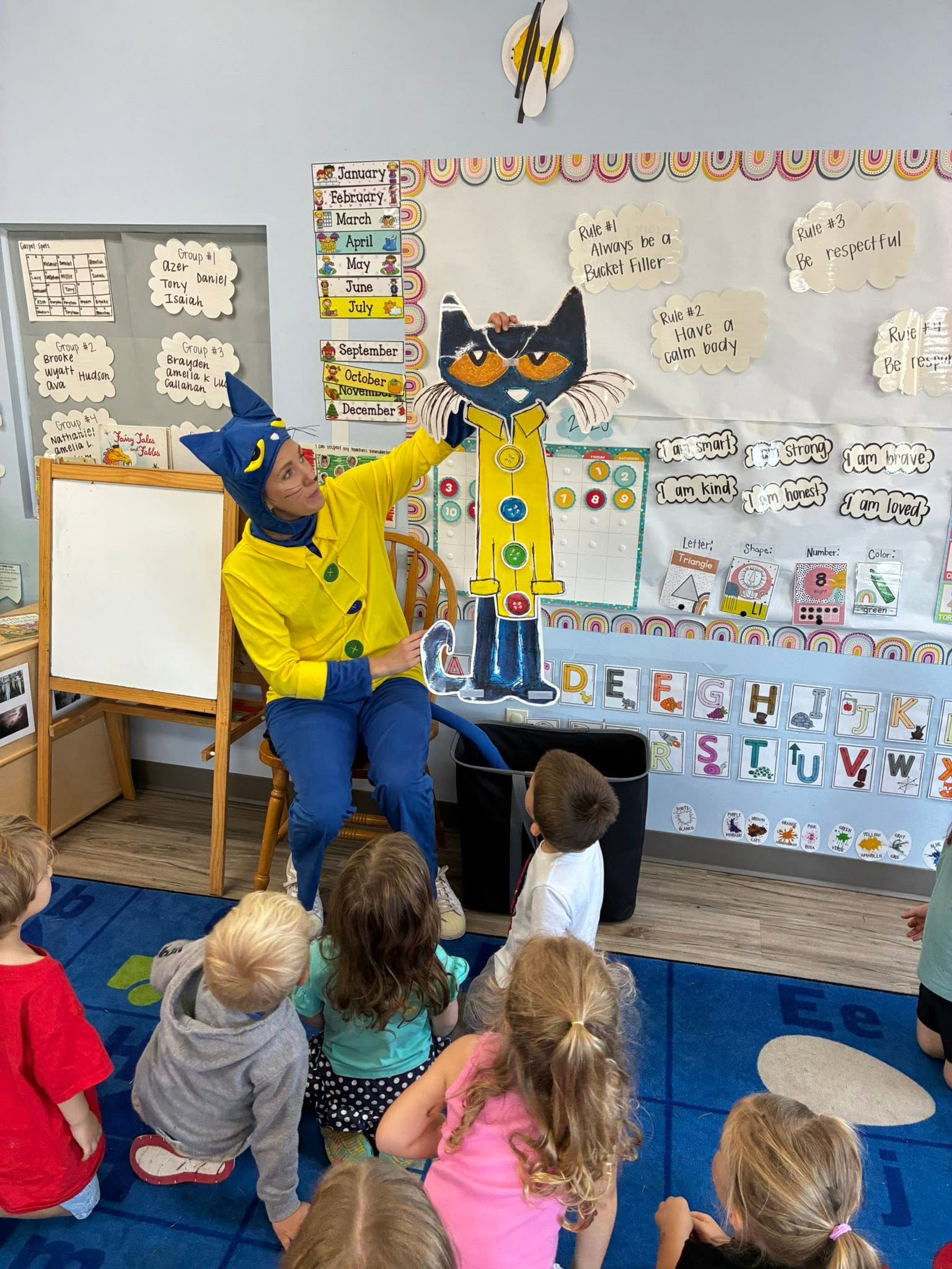 A teacher dressed as Pete the Cat reading to preschoolers during story time at Creative Kids Academy Elk River