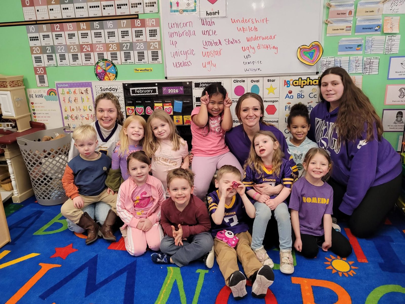 A classroom of children and teachers smiling together at Creative Kids Academy Lexington