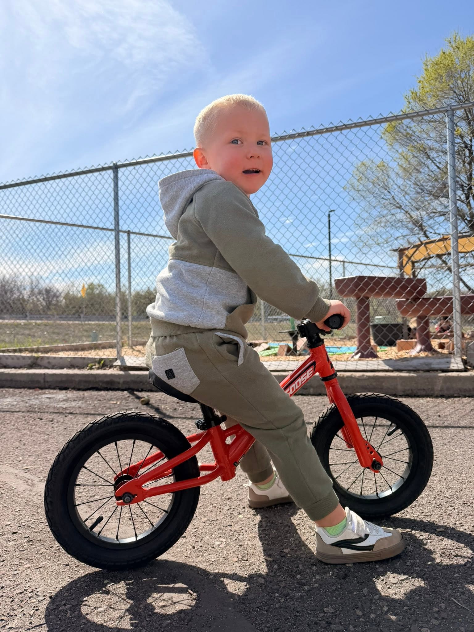 Toddler riding a balance bike on our outdoor play area