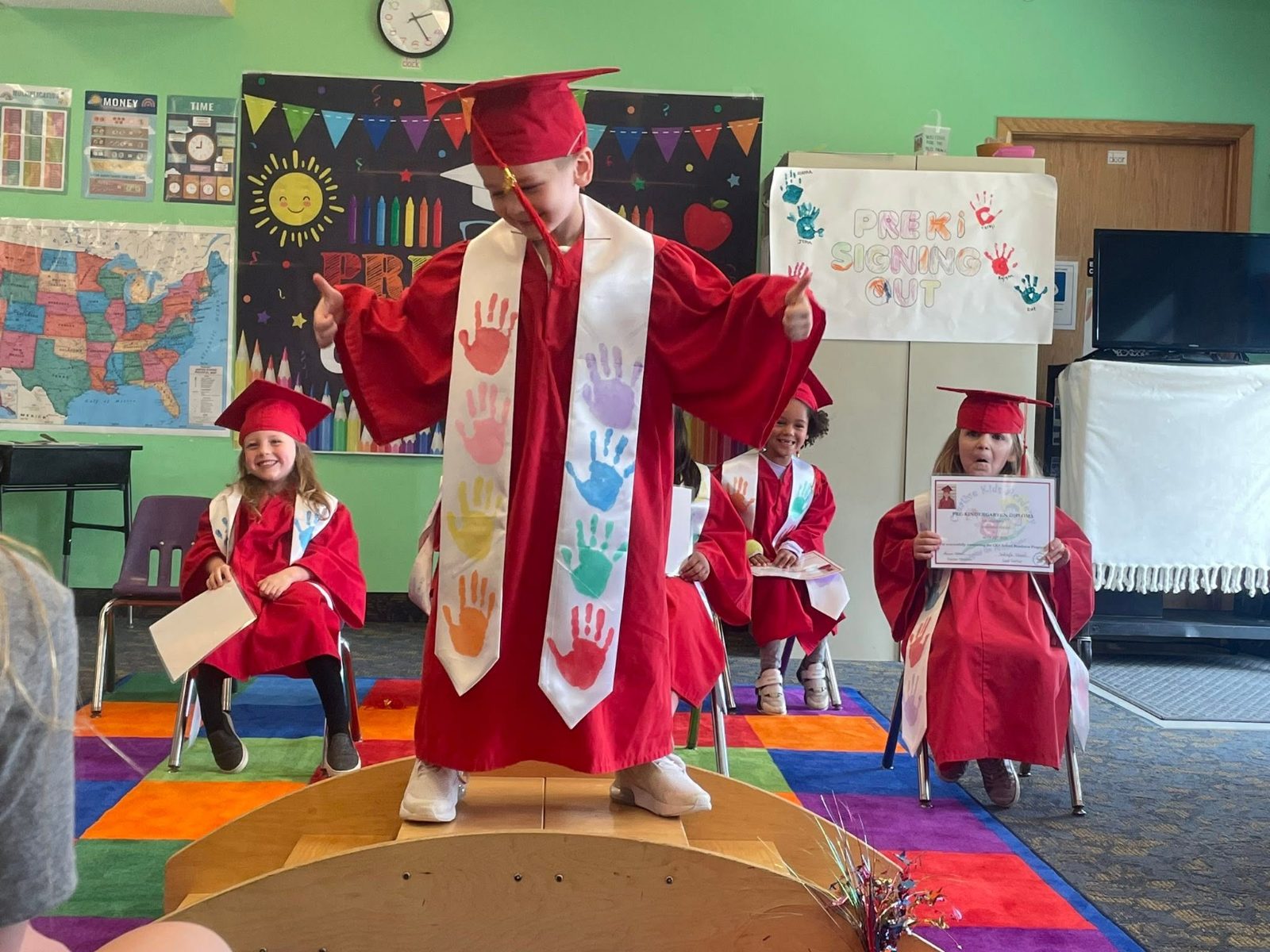 A Pre-K graduate celebrating in cap and gown at Creative Kids Academy Lexington
