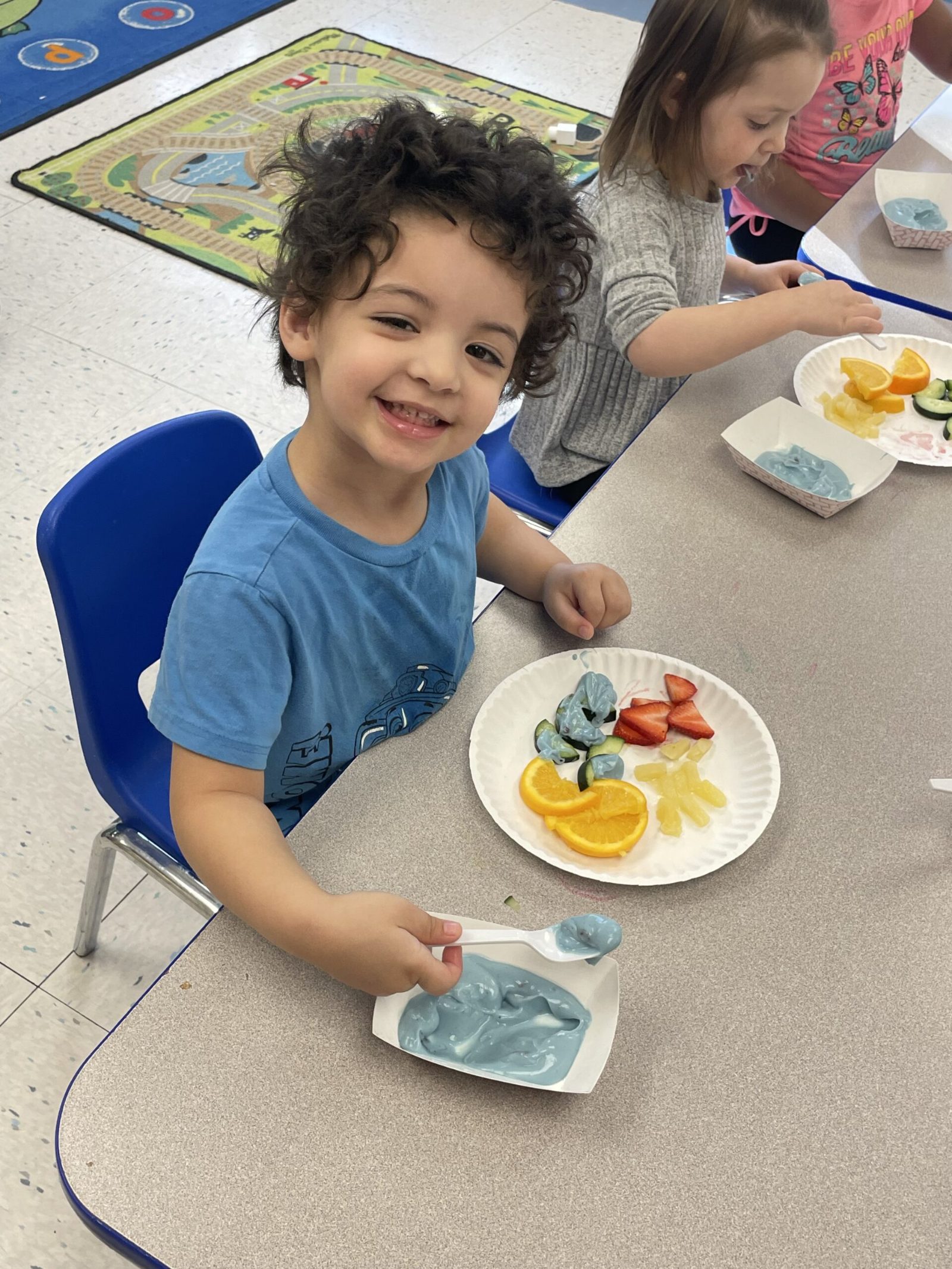 A preschooler enjoying fresh fruit at snack time