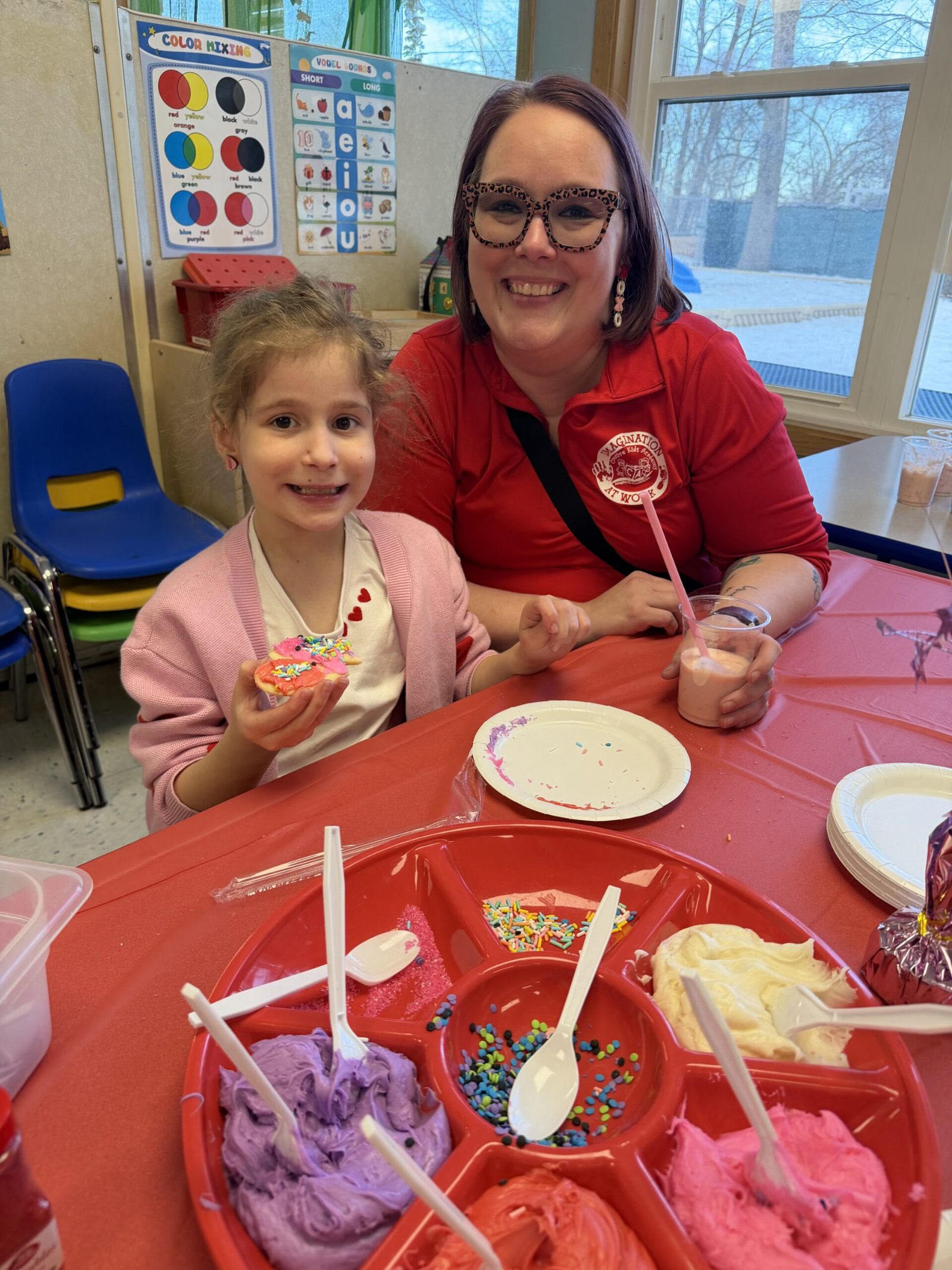Teacher and student decorating a cookie together