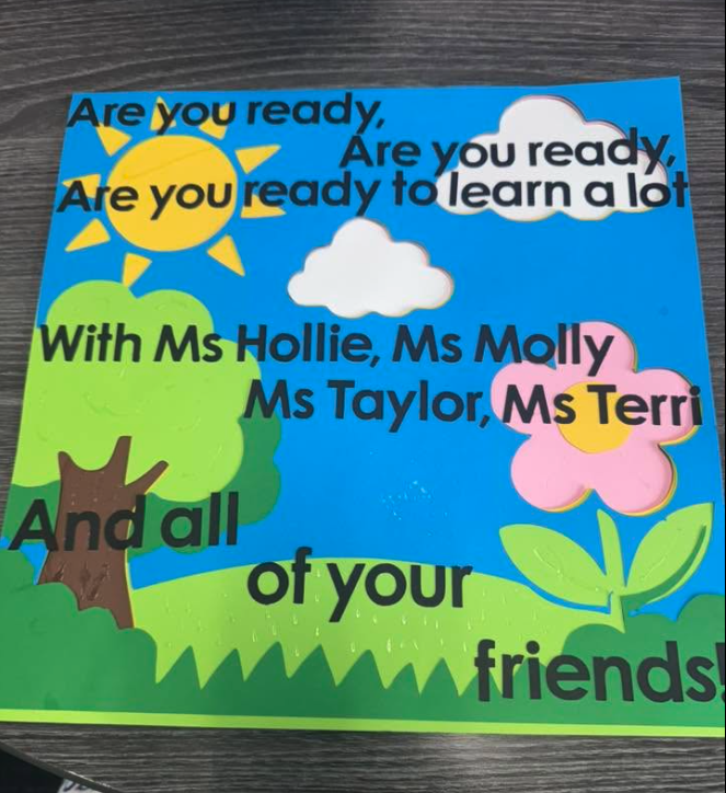 Colorful welcome-back classroom sign naming Ms. Hollie, Ms. Molly, Ms. Taylor, and Ms. Terri, the infant room teaching team at Creative Kids Academy Centerville.