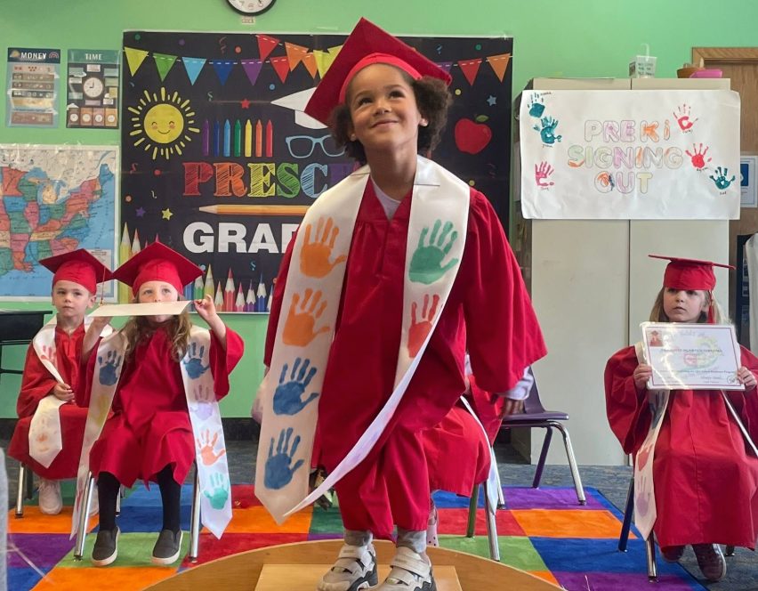 Preschool graduates celebrating in caps and gowns