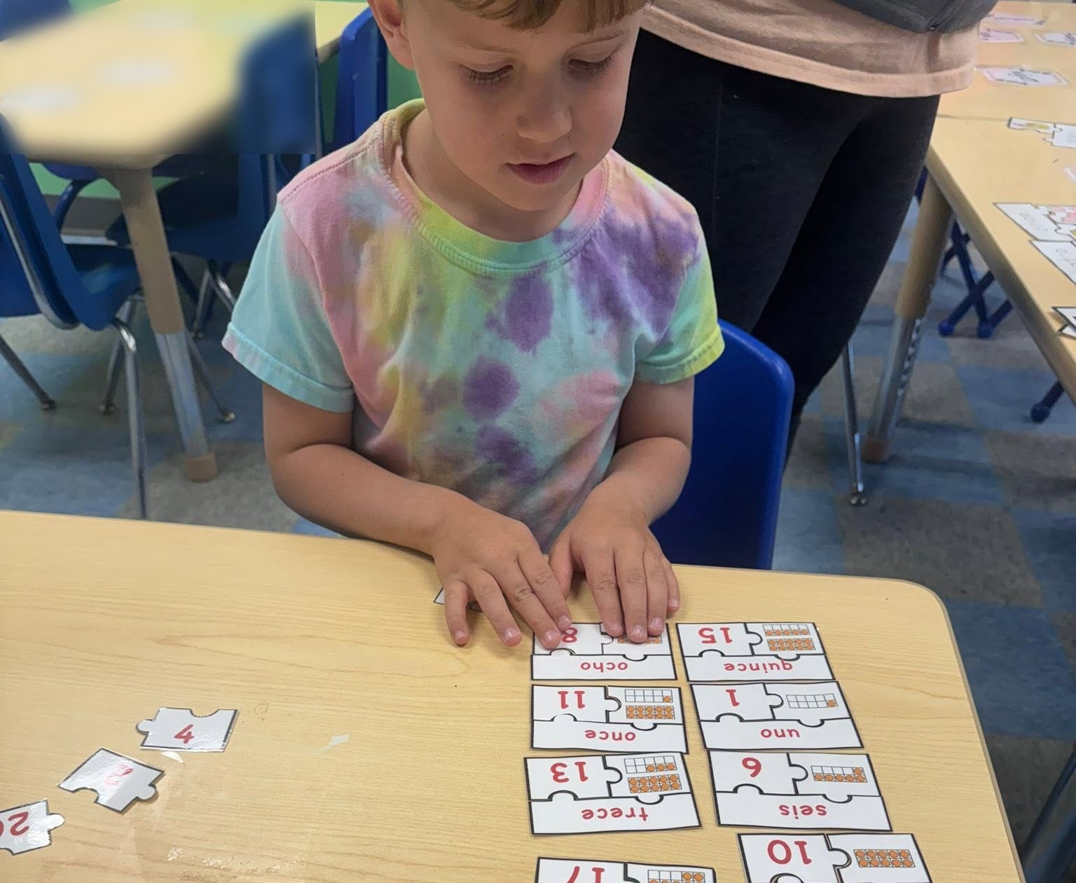 Preschooler matching Spanish number puzzles during a TLSA lesson at Creative Kids Academy