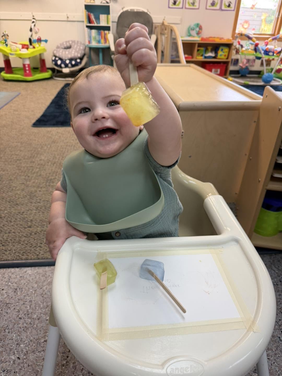 Baby exploring a frozen paint pop in the infant room at Creative Kids Academy Elk River on Hwy 10