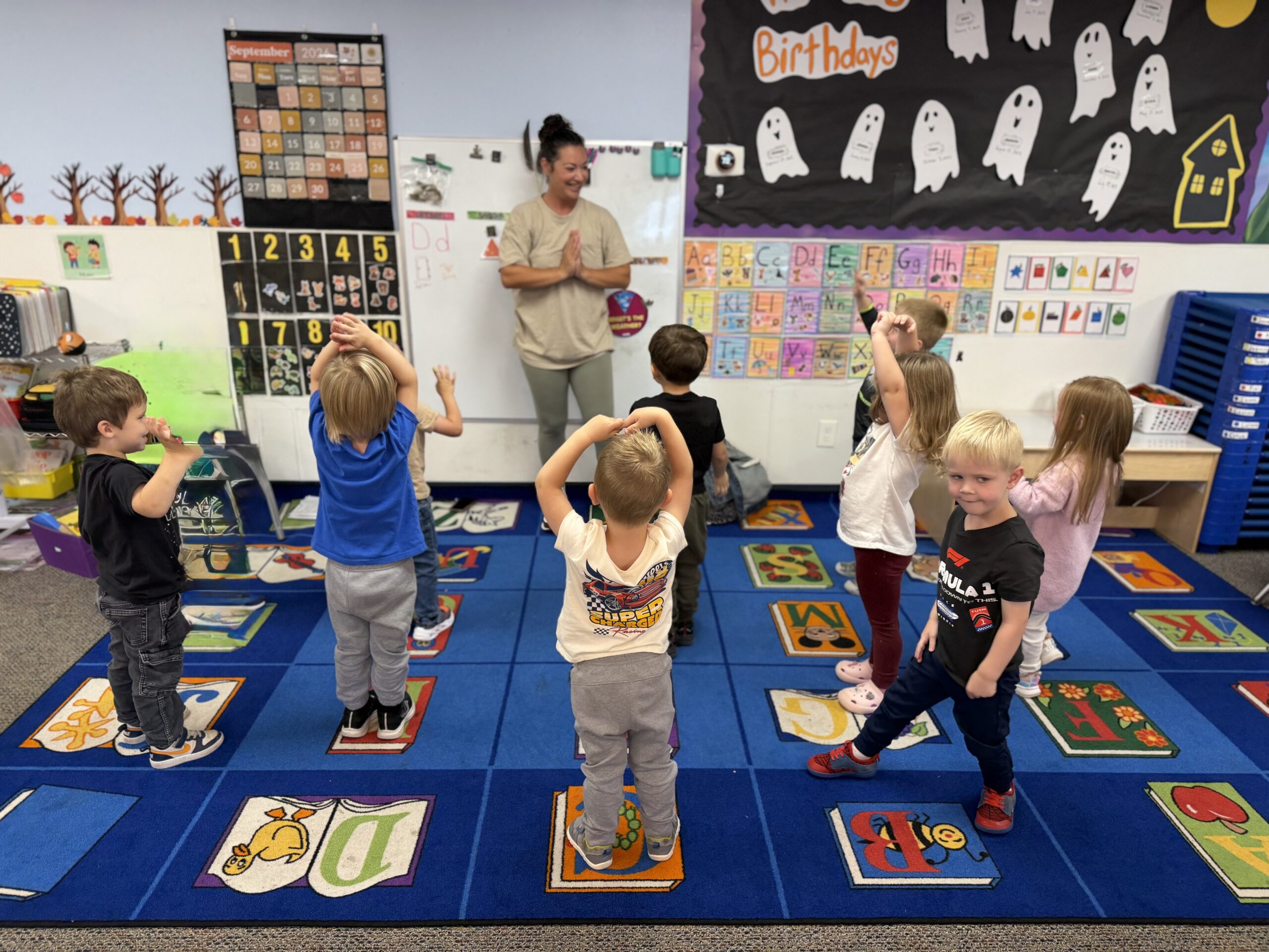 CKA preschoolers stretching with their teacher during a Kids Yoga class
